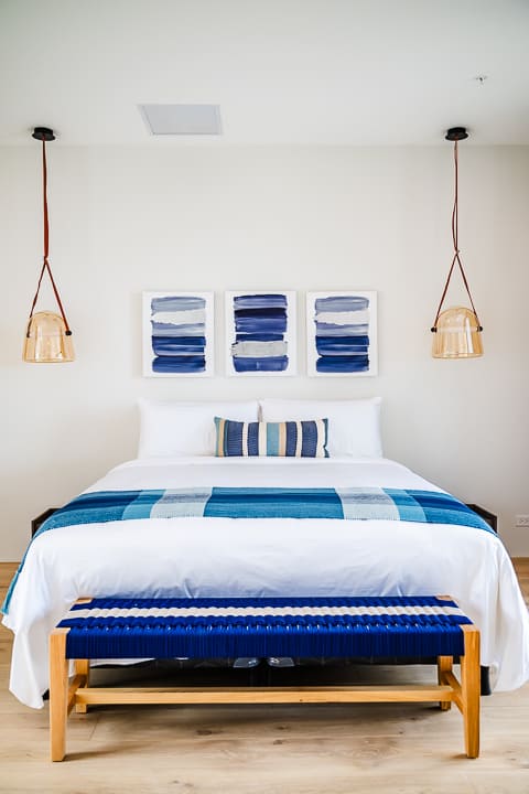 Luxury bedroom with floor-to-ceiling windows overlooking lush greenery and ocean views at the Reserva Conchal penthouse in Costa Rica