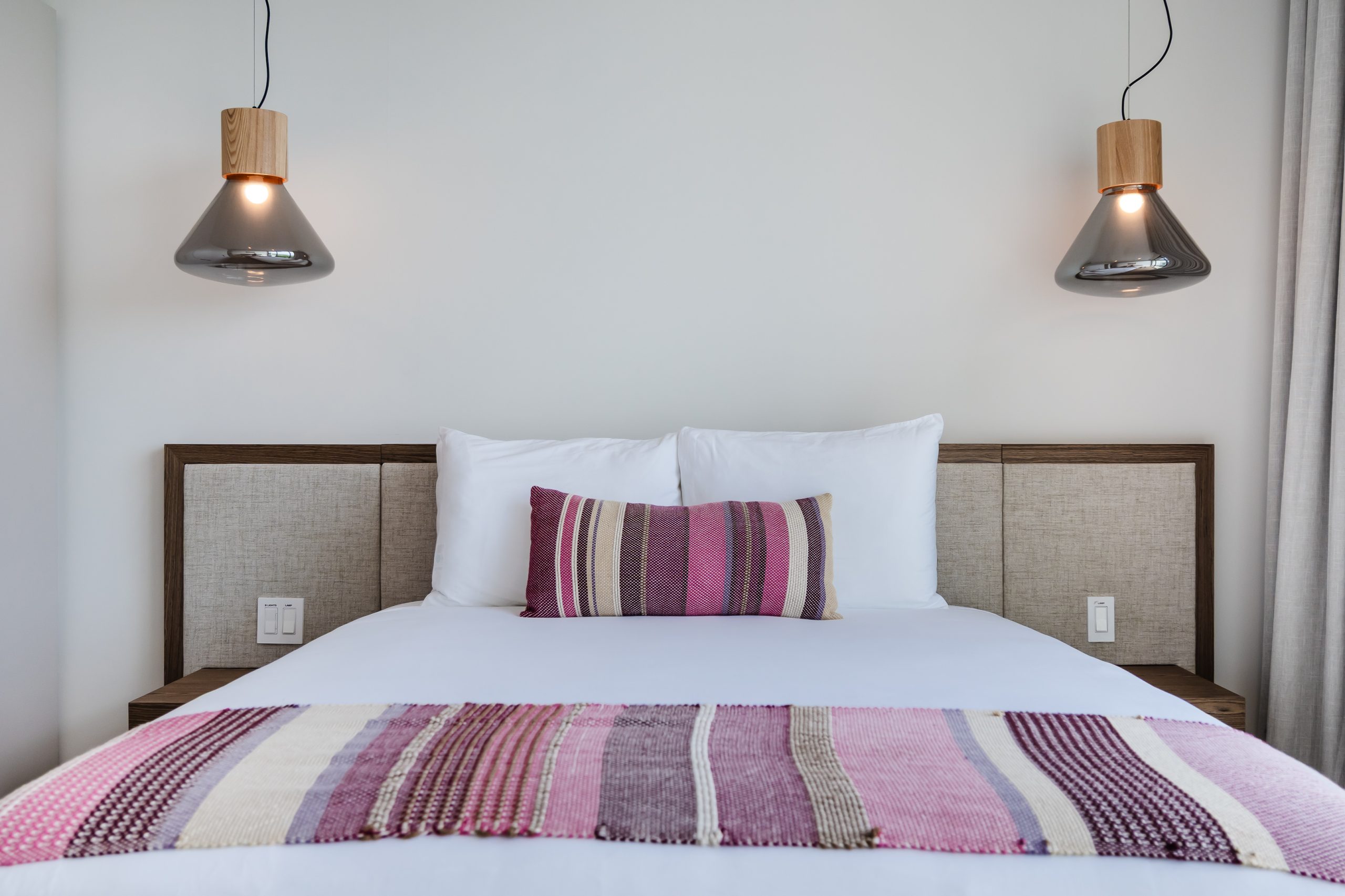 Luxury bedroom with floor-to-ceiling windows overlooking lush greenery and ocean views at the Reserva Conchal penthouse in Costa Rica