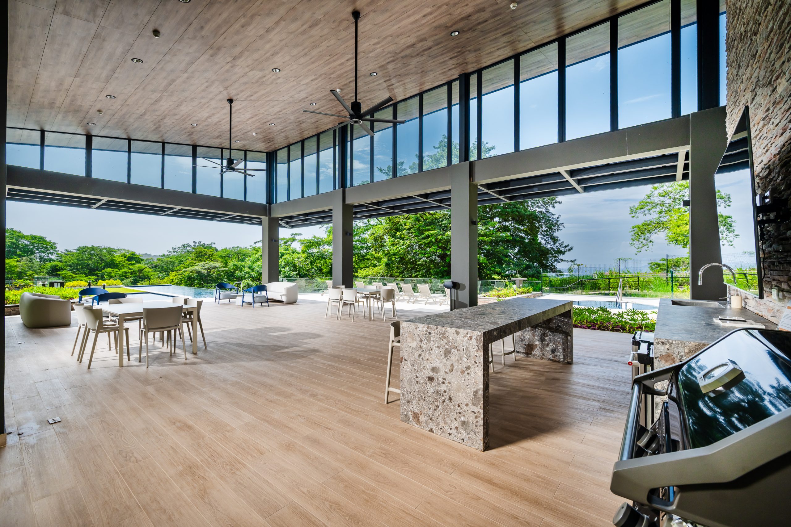 Open-concept Reserva Conchal clubhouse welcoming guests with elegant architecture, spacious lounge areas, and views of the surrounding tropical landscape.