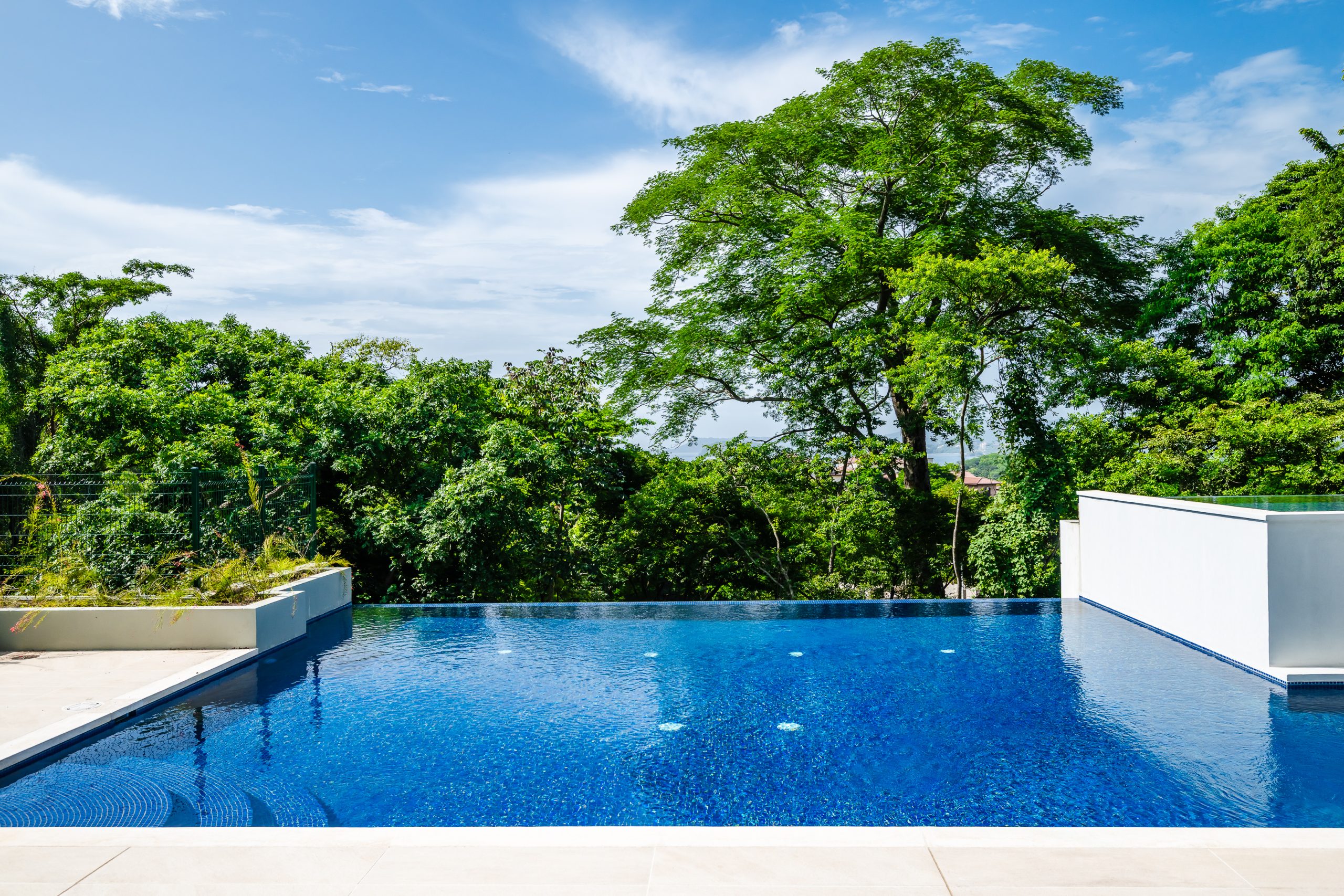 enjoy complimentary access to the luxury pool at the Reserva Conchal Clubhouse, surrounded by lush tropical gardens and offering a serene space to relax and unwind.