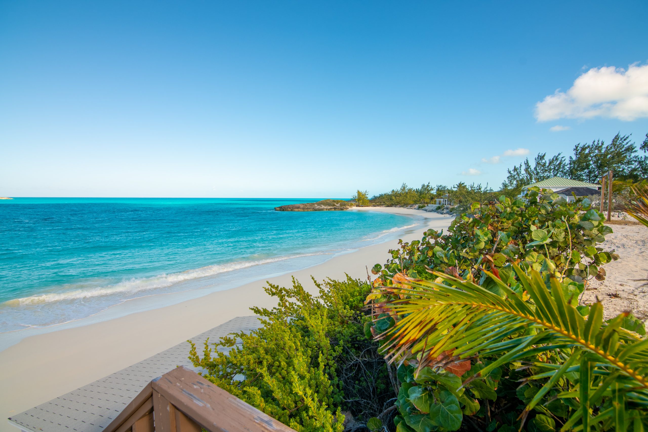 Pristine white sand beach and turquoise ocean along the Little Exuma shoreline in the Bahamas.