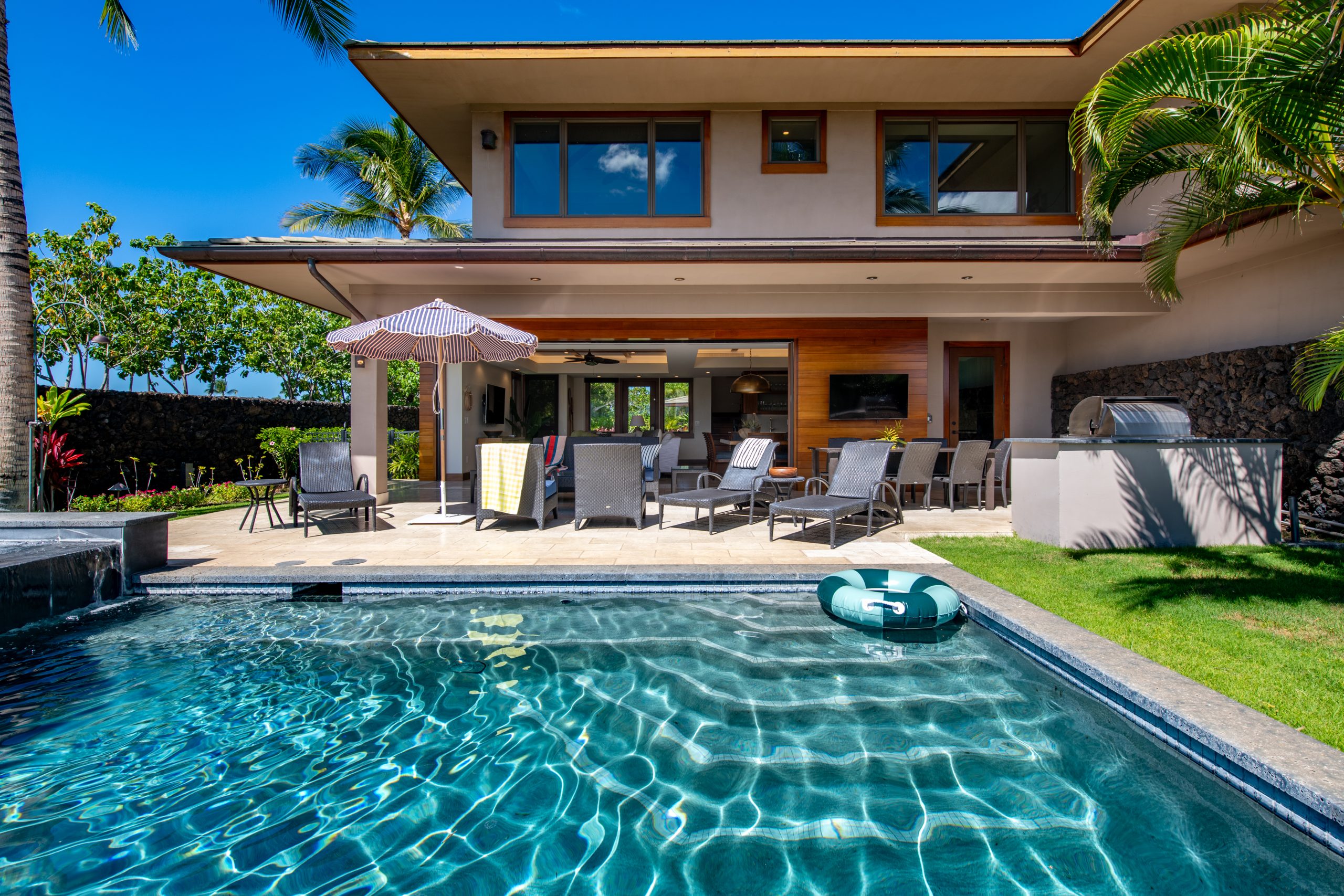 Private Mauna Lani villa with pool, lounge chairs, and outdoor dining under tropical sunshine.