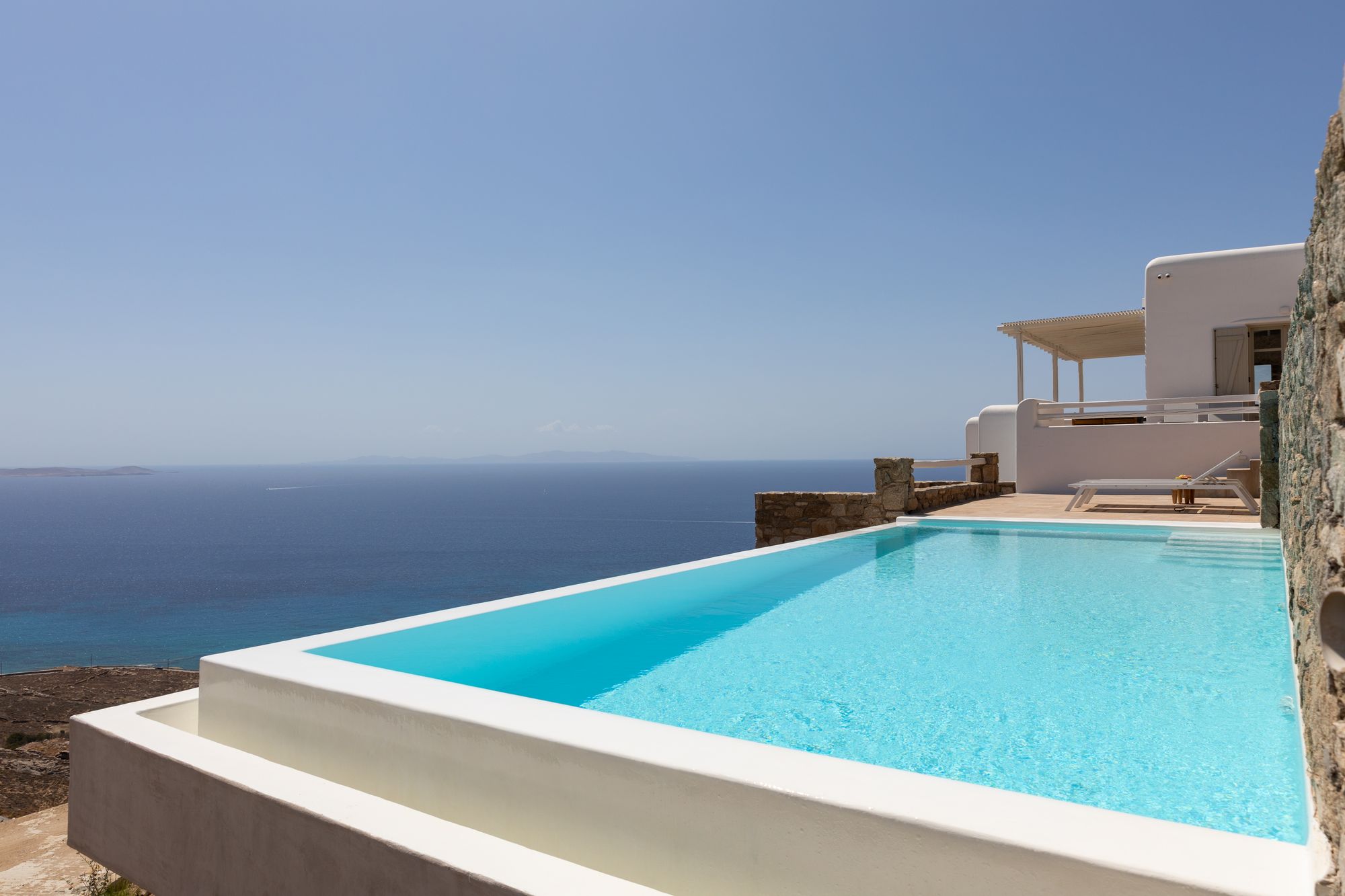 Whitewashed Mykonos villa with infinity pool and panoramic views of the Aegean Sea.