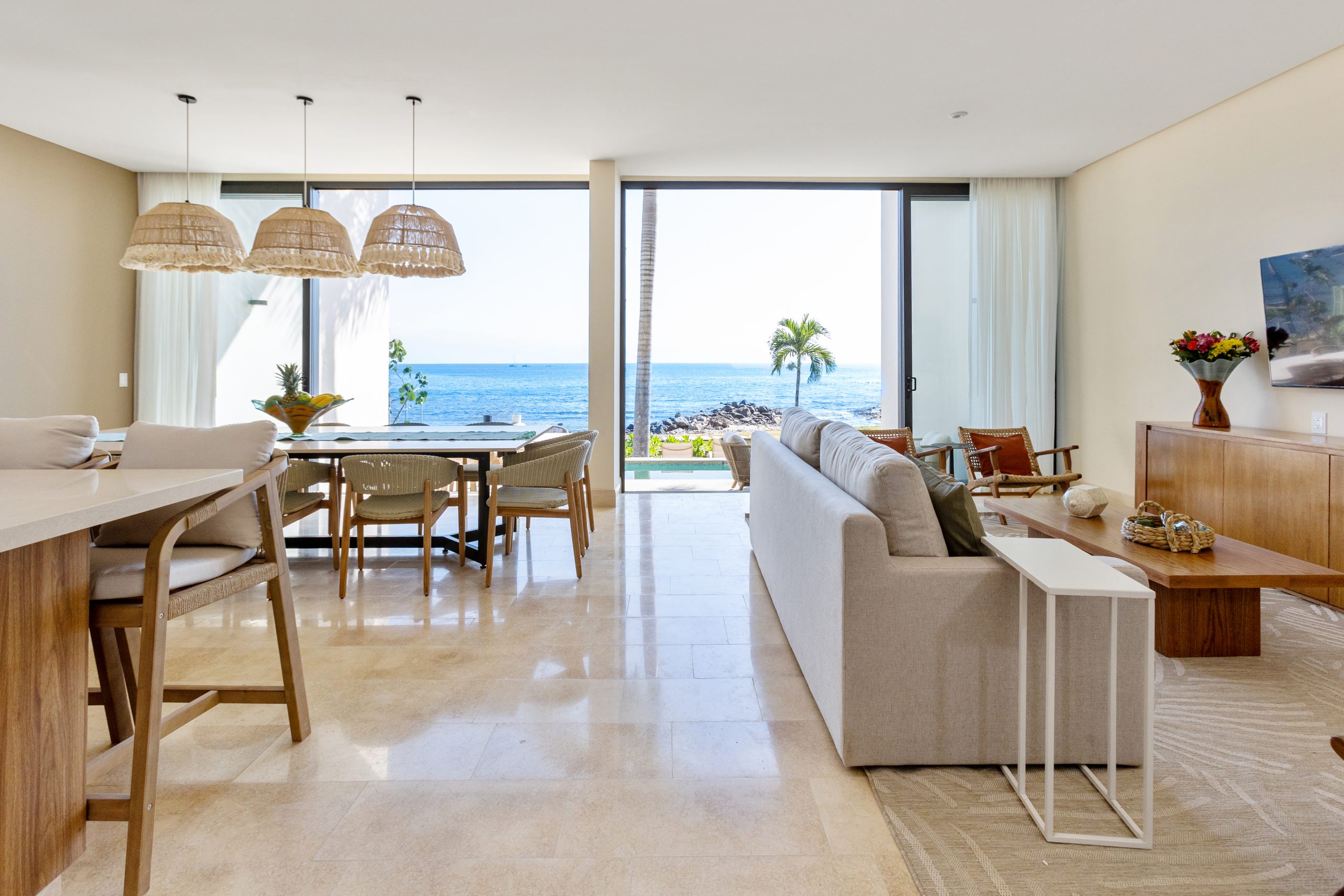 Oceanfront living room and dining area in a luxury Nuevo Vallarta villa with panoramic sea views.